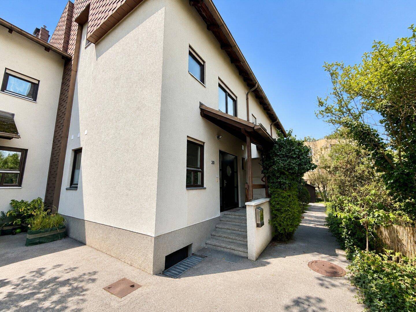 Außenansicht eines Wohnhauses mit Eingangsbereich und gepflegter Fassade.