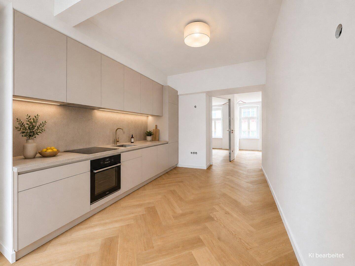Moderne Einbauküche in hellem Grau mit integrierten Geräten und Fischgrätparkett.