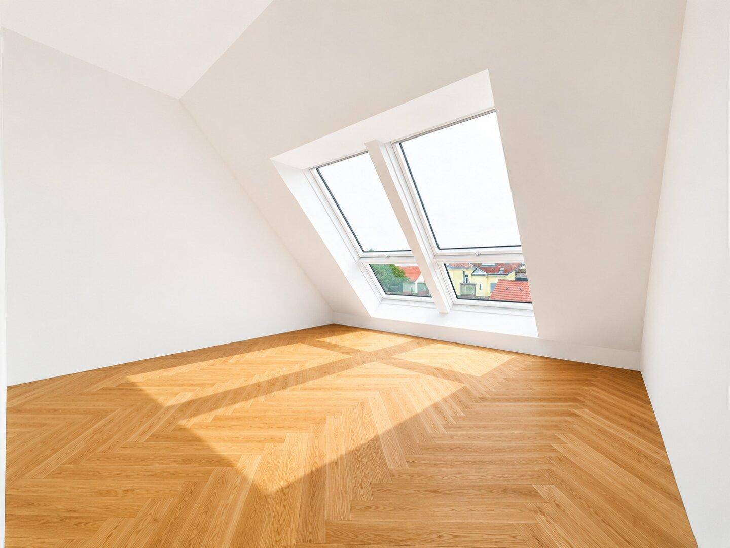Heller Raum mit Fischgrätparkett, großen Dachfenstern und Blick auf die Umgebung.