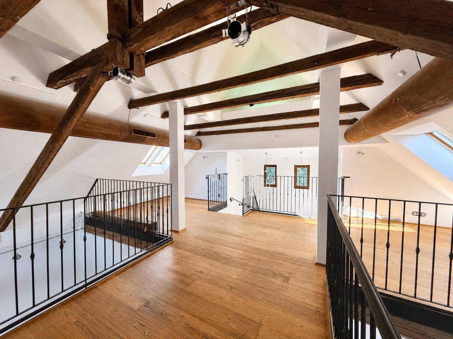 Offene Galerie mit Holzboden und sichtbaren Balken, die den darunterliegenden Raum überblickt.
