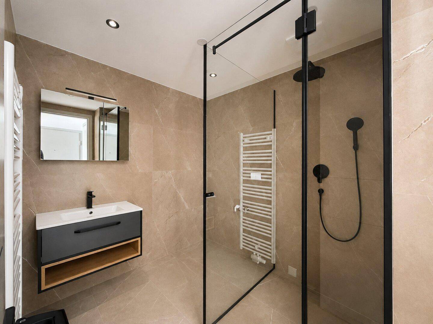 Modernes Badezimmer mit beigefarbenen Fliesen, begehbarer Dusche und stilvollem Waschtisch.