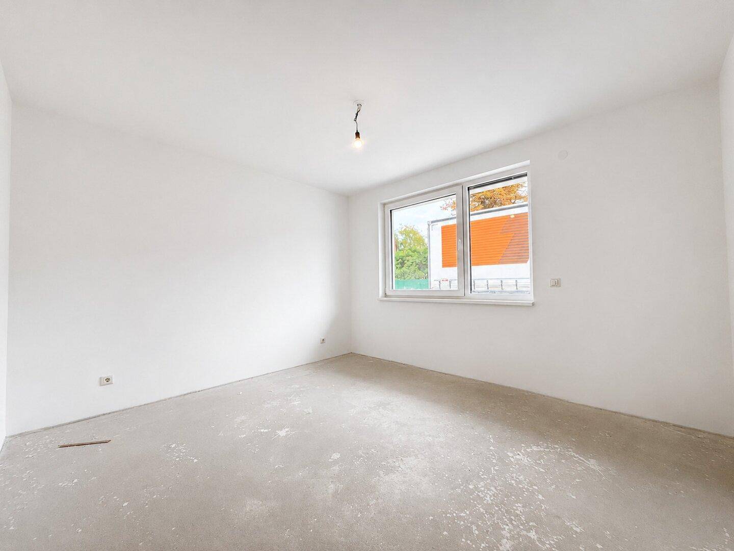 Leerer Raum mit einem großen Fenster, ideal als Schlaf- oder Arbeitszimmer.