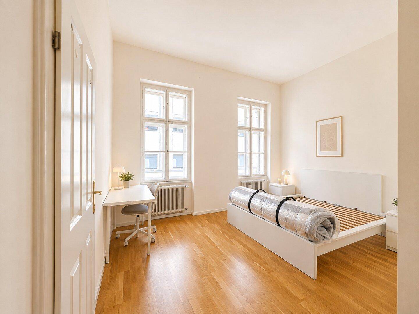 Geräumiges Schlafzimmer mit Parkettboden und zwei großen Fenstern, bietet viel Gestaltungspotenzial.