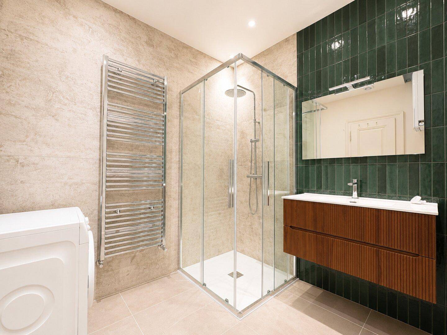 Modernes Badezimmer mit begehbarer Dusche, schwebendem Waschtisch und beheiztem Handtuchhalter.