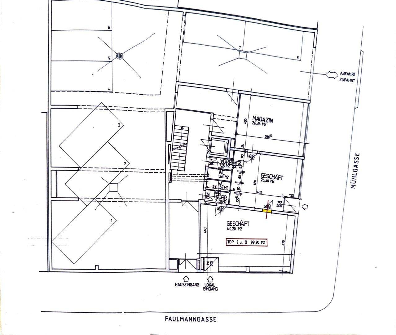 Grundrissplan eines Gebäudes mit Geschäftsflächen, Lagerräumen und Zufahrt zu einer Tiefgarage.