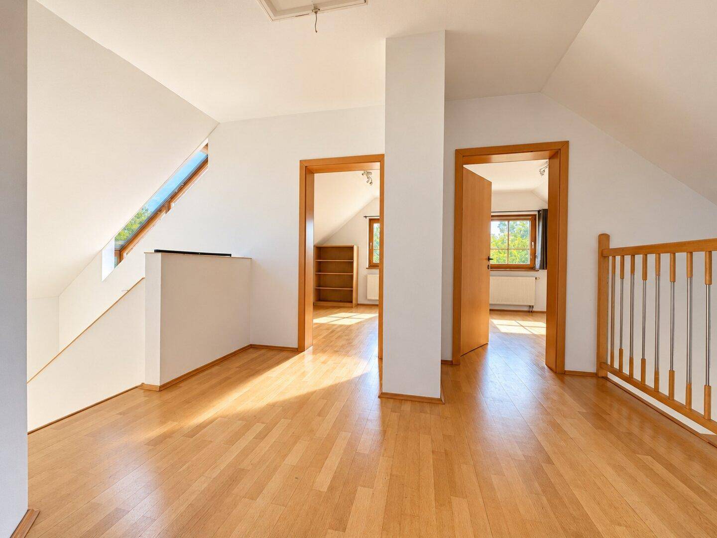 Heller Flur im Obergeschoss mit Parkettboden, Dachschrägen und Zugang zu weiteren Räumen.