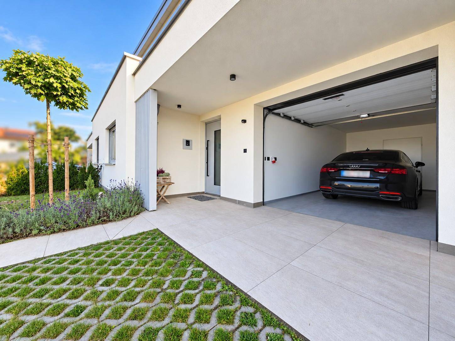 Modernes Einfamilienhaus mit Garage, Carport und gepflegtem Vorgarten.