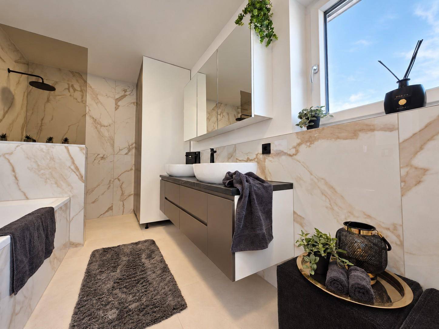 Modernes Badezimmer mit Marmorfliesen, Doppelwaschbecken und begehbarer Dusche, hell und geräumig.