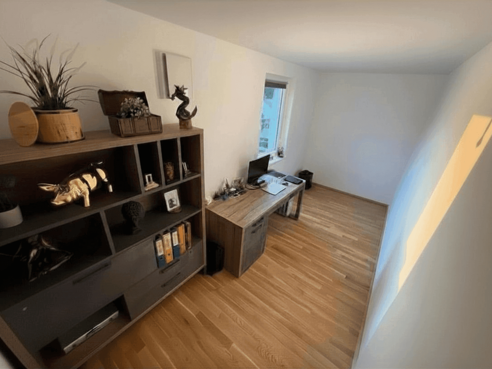 Helles Arbeitszimmer mit Holzboden, Schreibtisch und Regal für eine produktive Arbeitsumgebung.