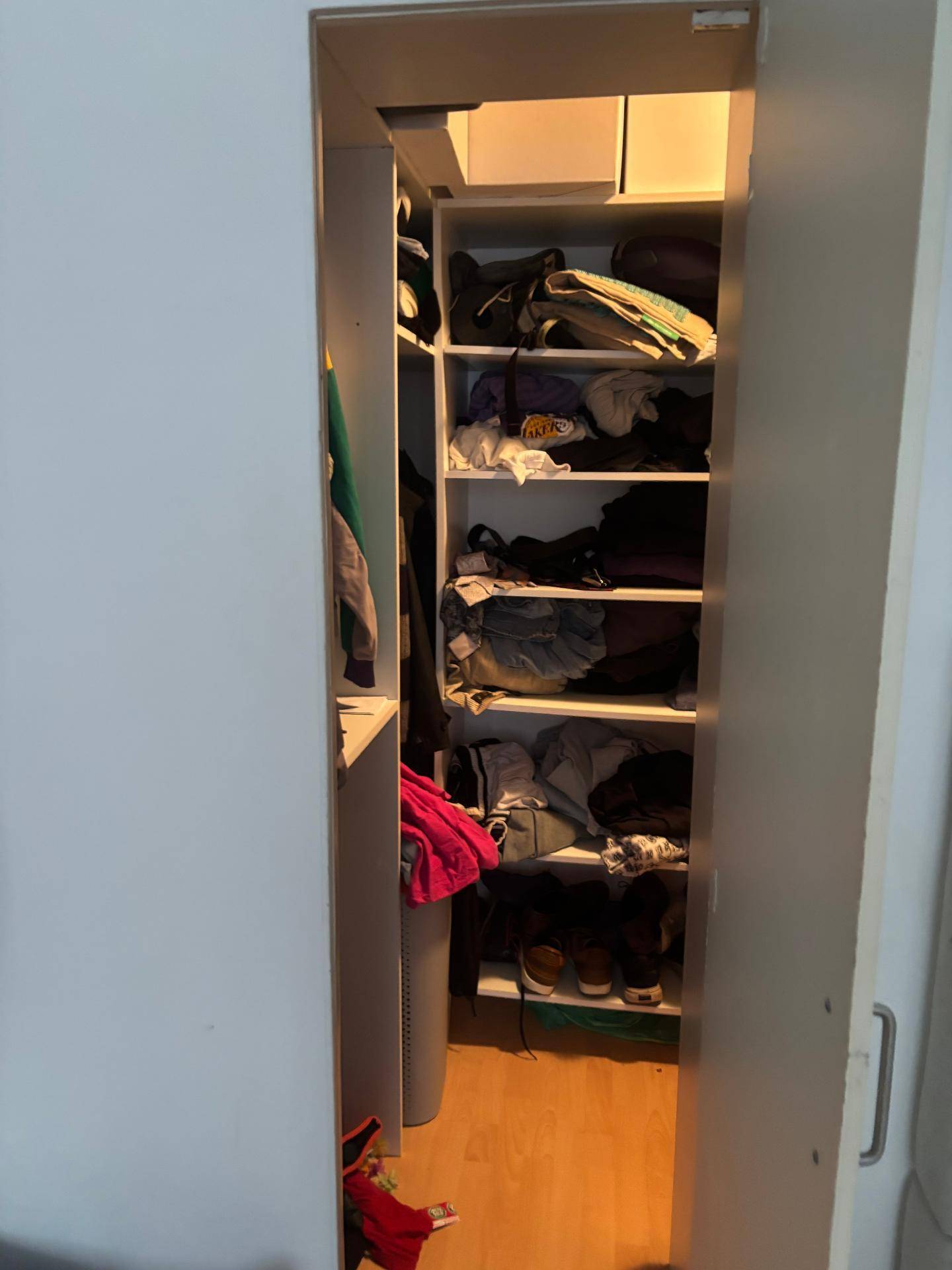 Begehbarer Kleiderschrank mit Regalen und Stauraum für Kleidung und Schuhe.
