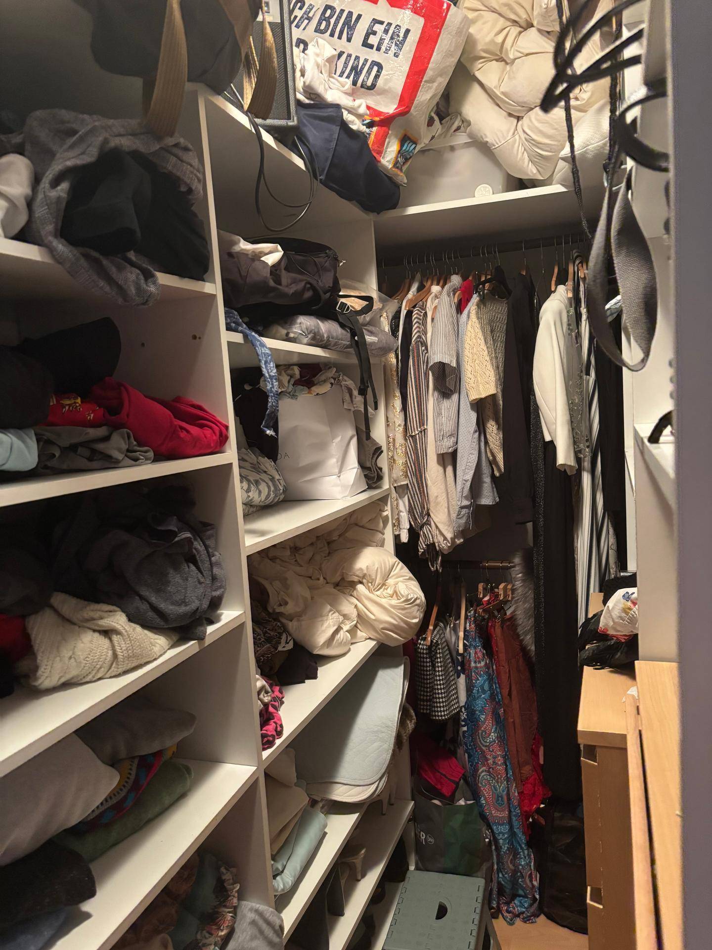 Gut organisierter begehbarer Kleiderschrank mit vielen Regalen und Kleiderstangen.