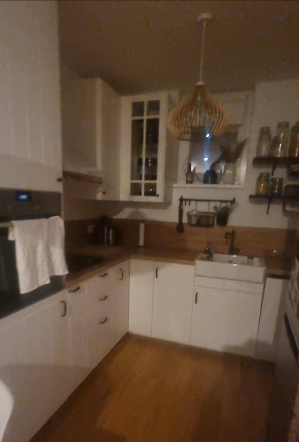 Helle Küche mit weißen Schränken, Holz-Arbeitsplatten und einem integrierten Backofen.