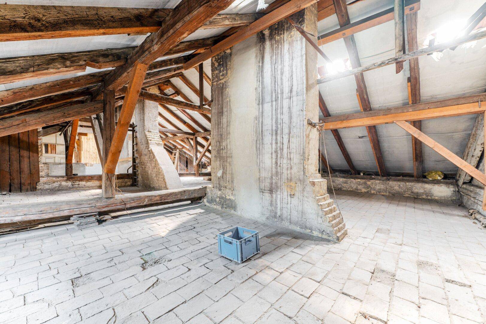 Großer Dachboden mit Holzbalken, Ziegelboden und viel Potenzial für zukünftige Nutzung.