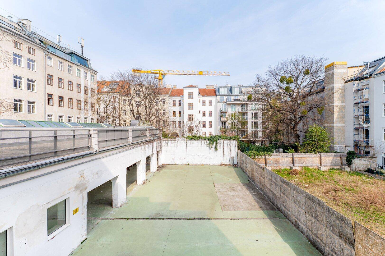 Weitläufiger Innenhof mit Garagen und umliegenden Altbauten, ideal für Parkmöglichkeiten.