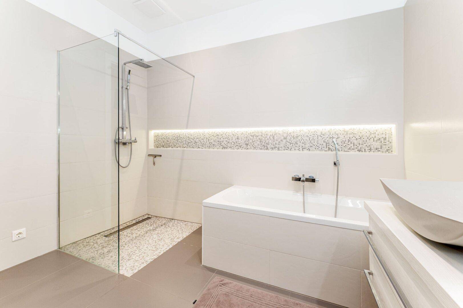 Modernes Badezimmer mit Badewanne, begehbarer Dusche und stilvoller Mosaikfliesen-Akzentwand.