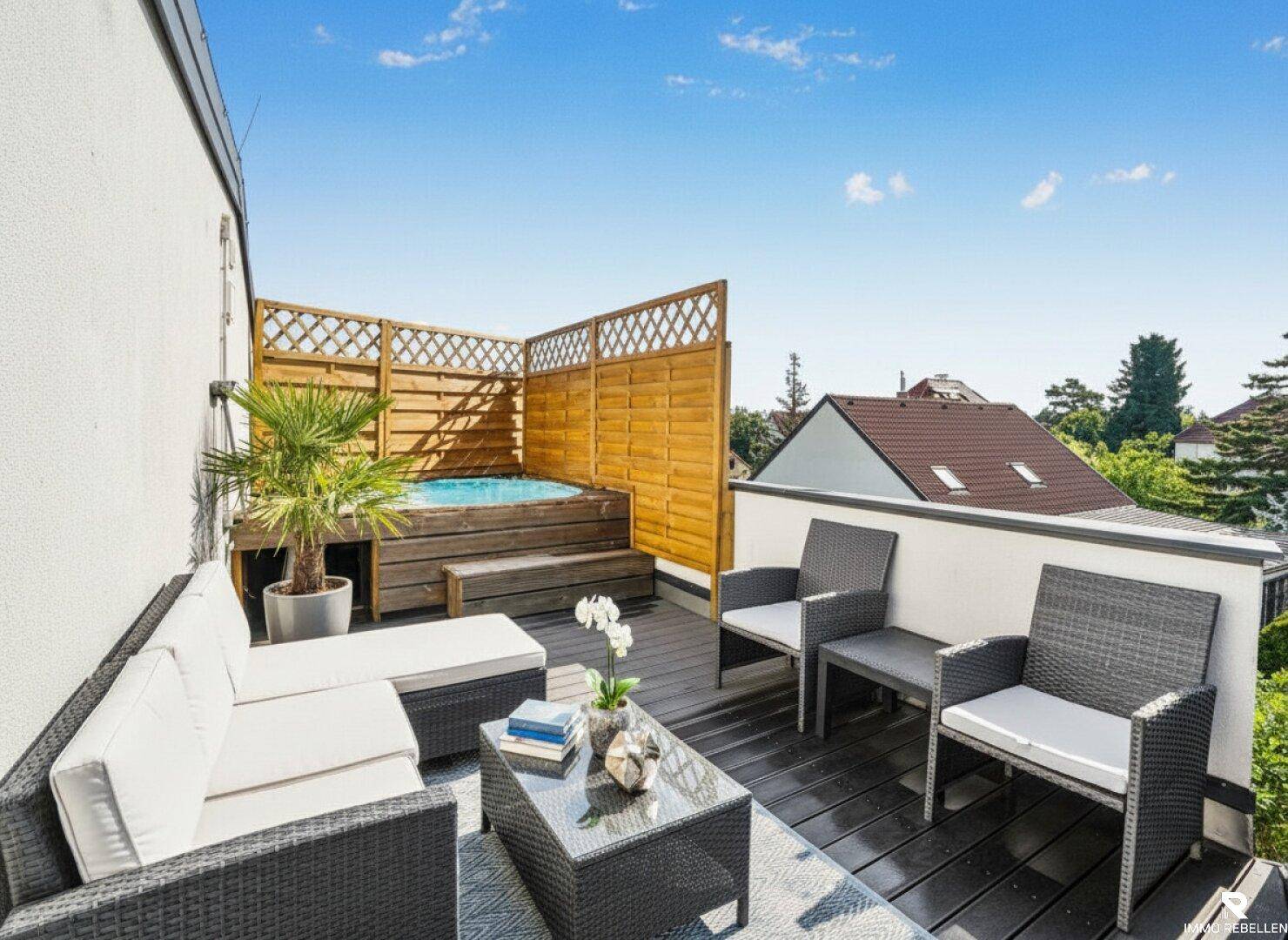Gemütliche Dachterrasse mit Whirlpool, Sitzgelegenheiten und Holzsichtschutz.