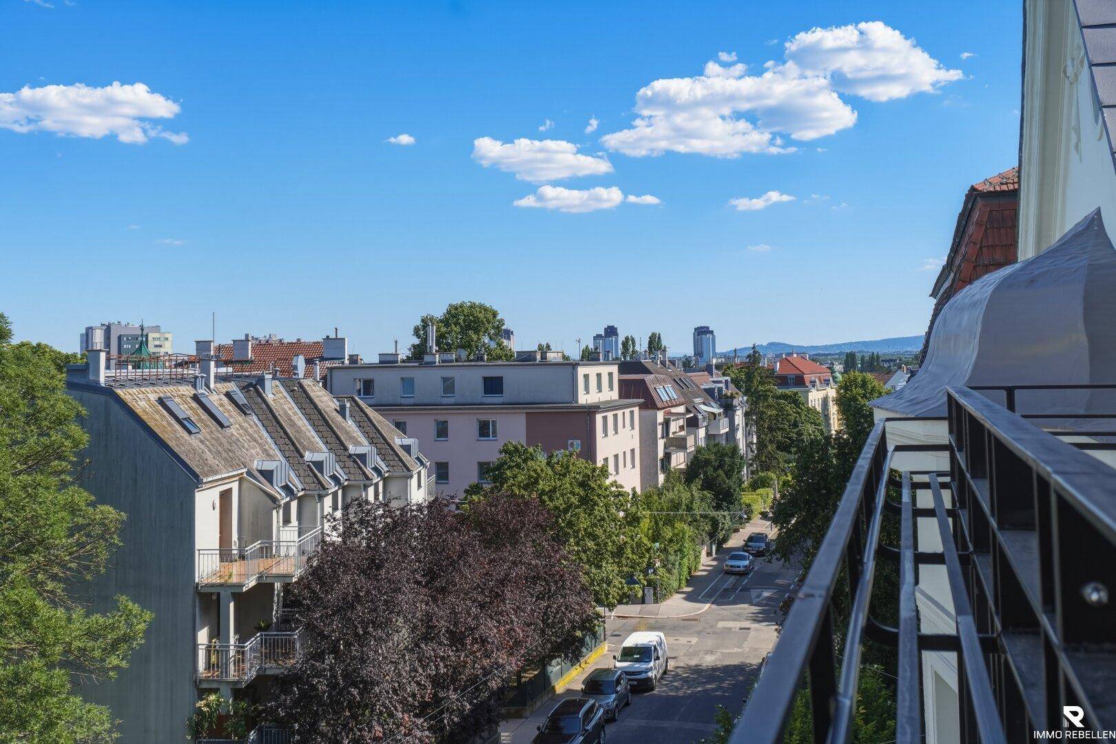 Balkon mit Blick auf die ruhige Wohnstraße und die umliegenden Gebäude.