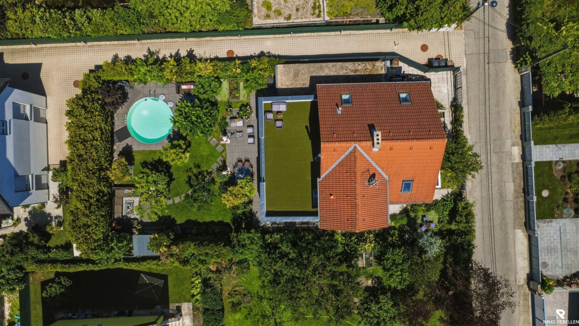 Vogelperspektive des Anwesens mit Haus, Pool, Garten und begrüntem Flachdach.