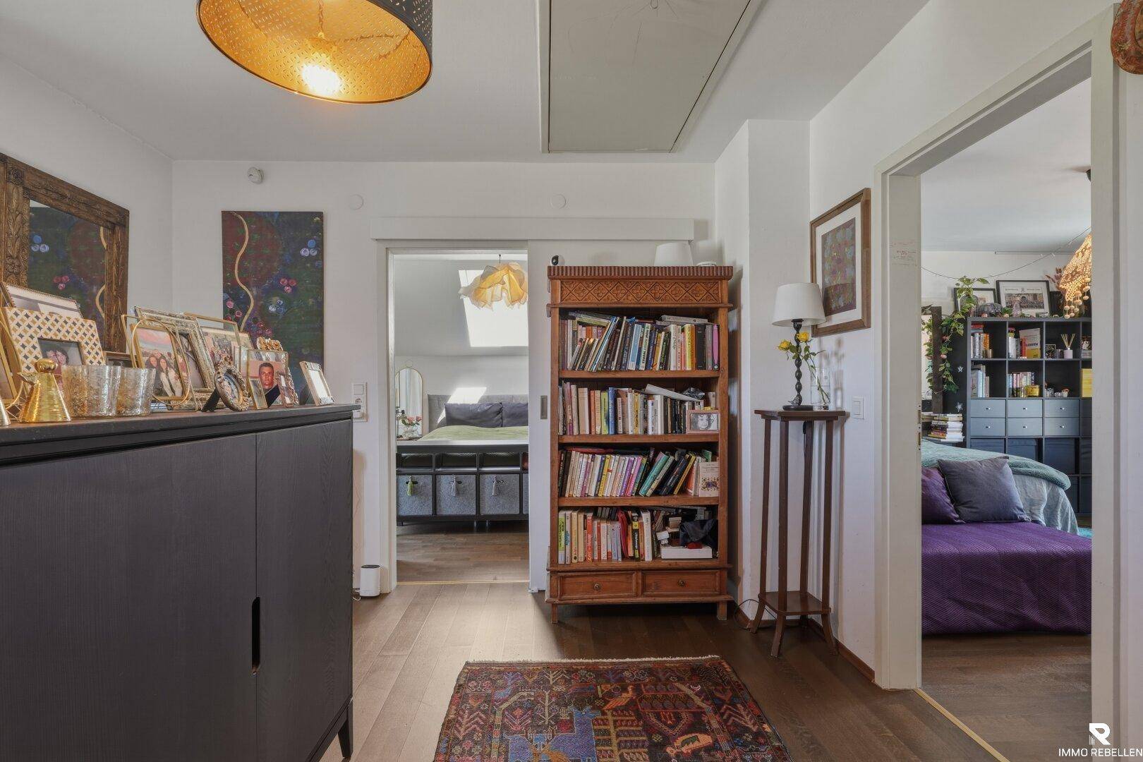 Heller Flur mit Bücherregal und Zugang zu den angrenzenden Schlafzimmern.