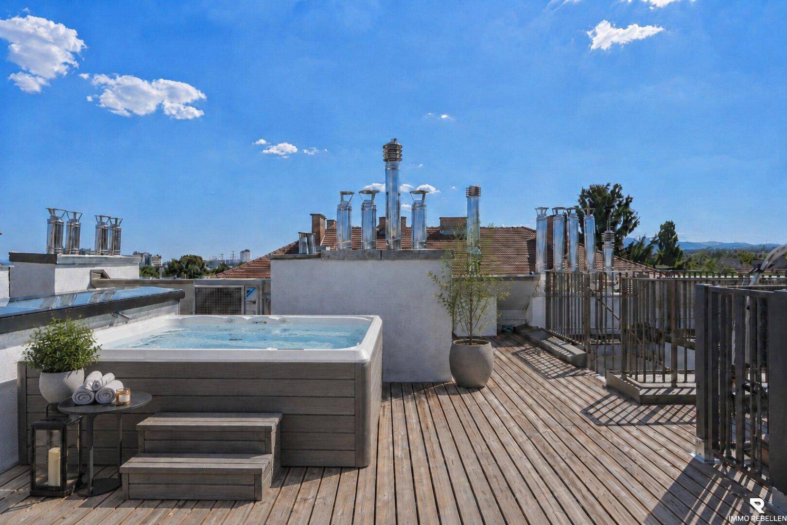 Exklusive Dachterrasse mit modernem Whirlpool und weitem Blick über die Stadt.