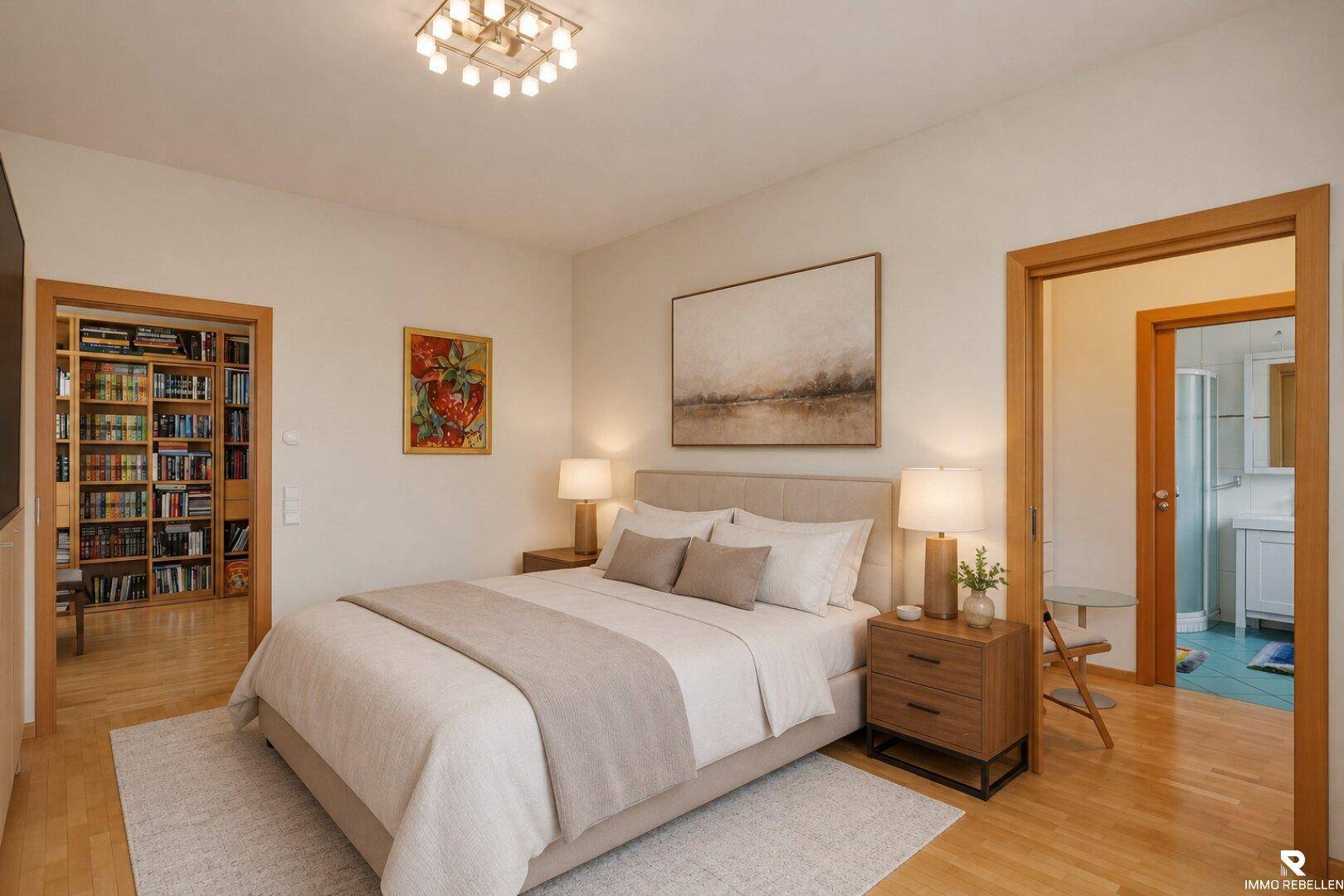 Helles Schlafzimmer mit Holzboden, Doppelbett und Zugang zu einem Badezimmer und einem Bücherzimmer.