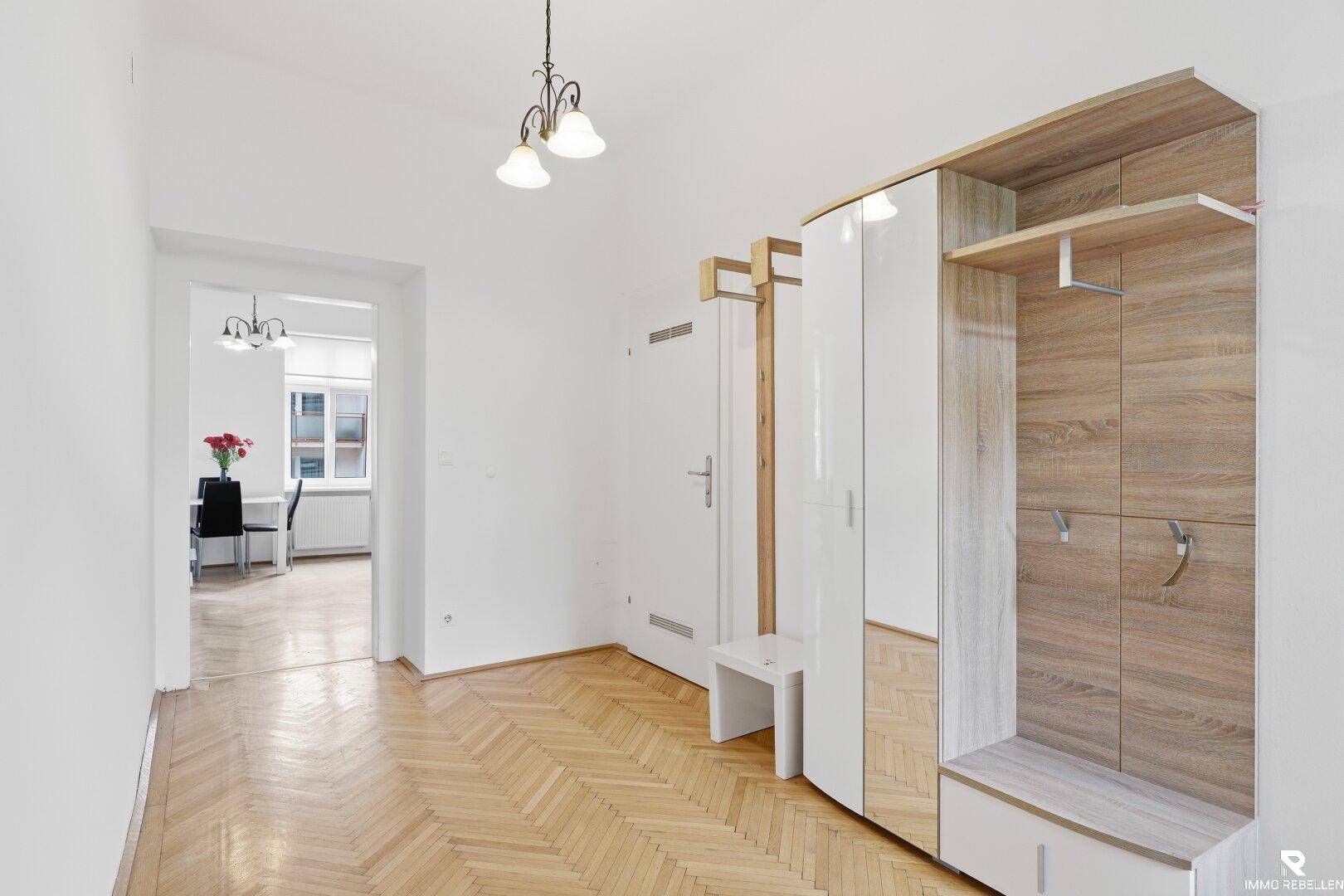 Heller Flur mit Fischgrätparkett und einem modernen Garderobenschrank.