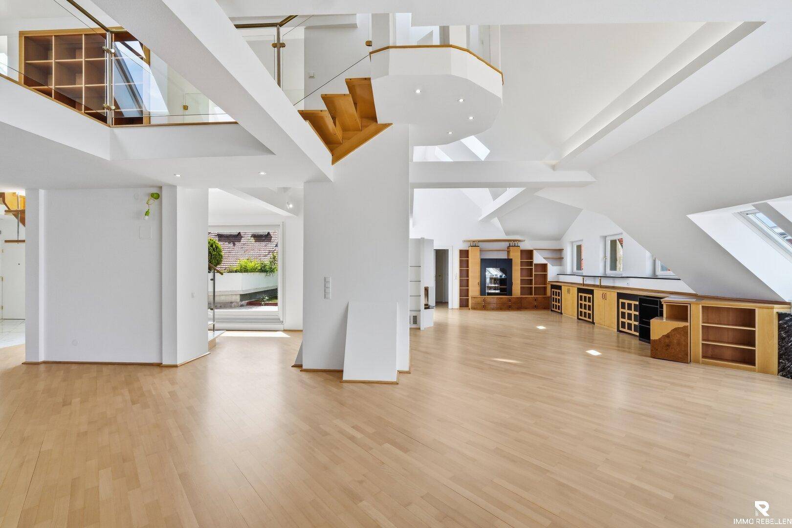 Geräumiger, leerer Wohn- und Essbereich mit Holzboden, hohen Decken und offener Galerie.