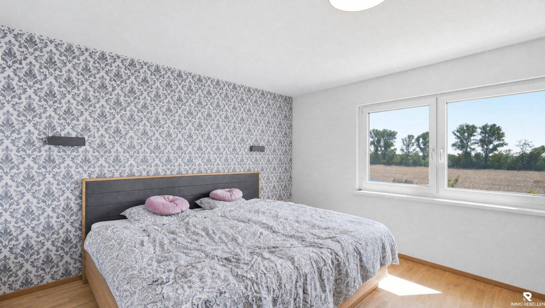 Geräumiges Schlafzimmer mit Doppelbett, gemusterter Tapete und weitem Blick ins Grüne.