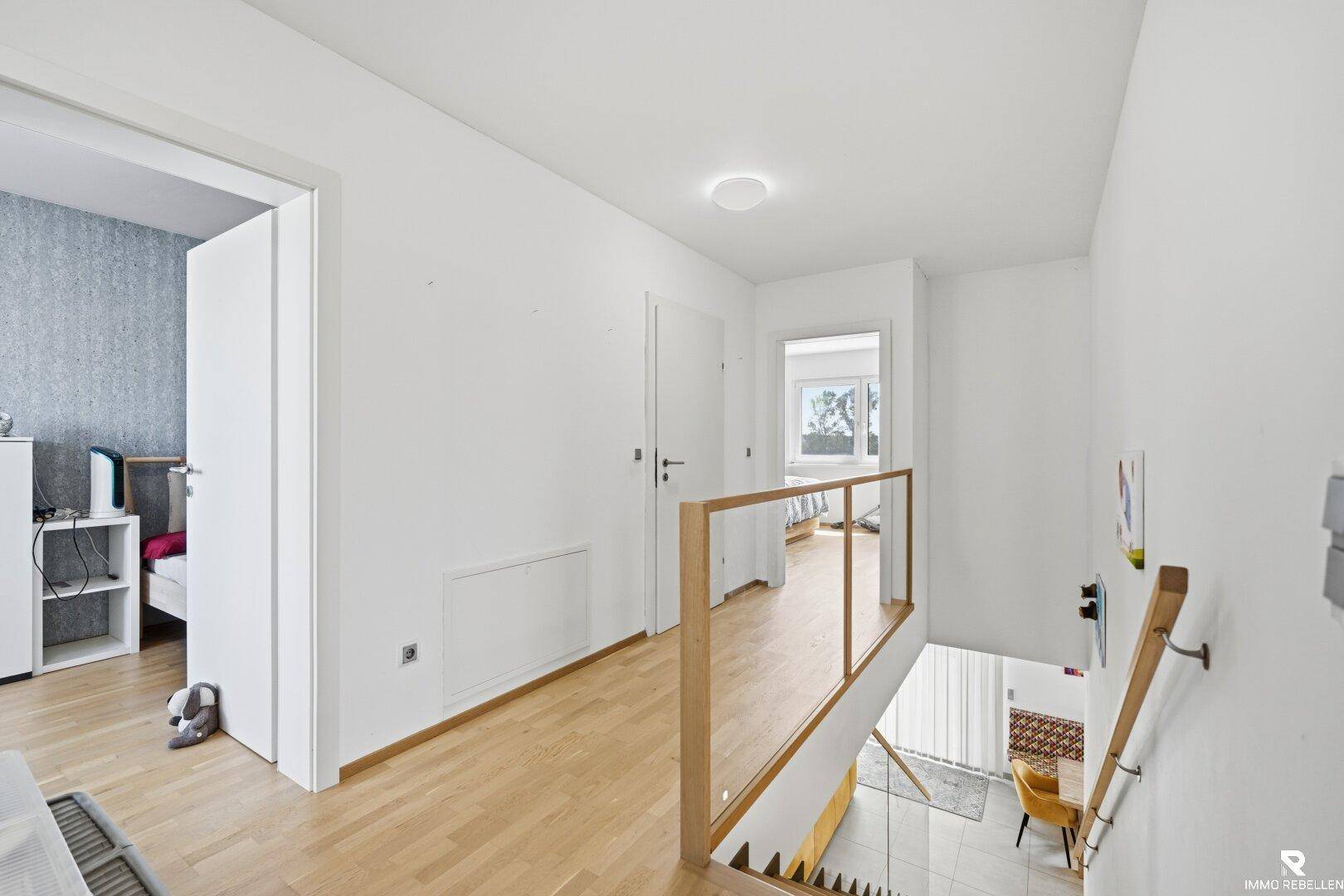Heller Flur im Obergeschoss mit Holzfußboden und Blick auf die Treppe.