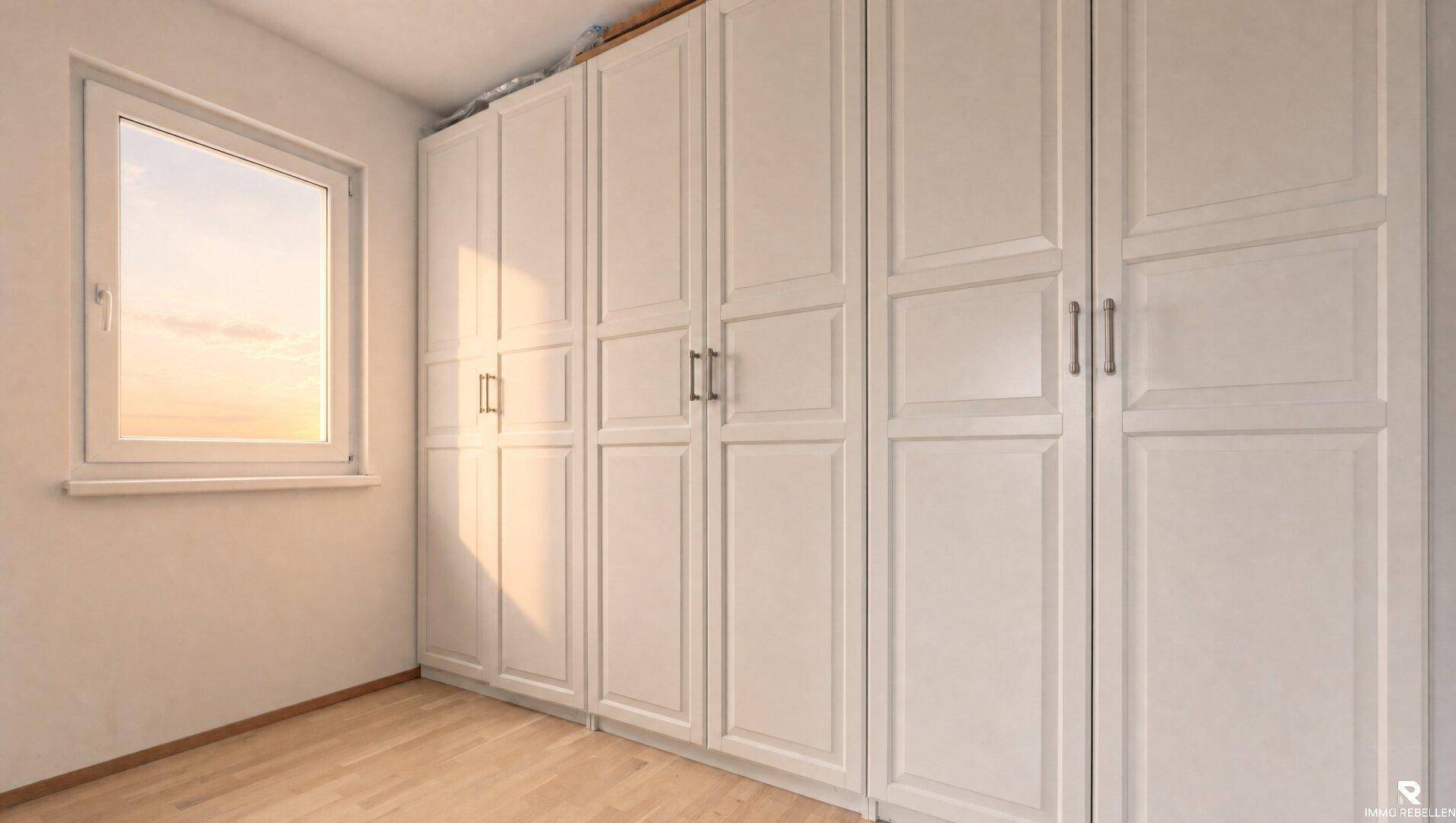 Geräumiger Raum mit großen Einbauschränken und Fenster, ideal als Ankleidezimmer.
