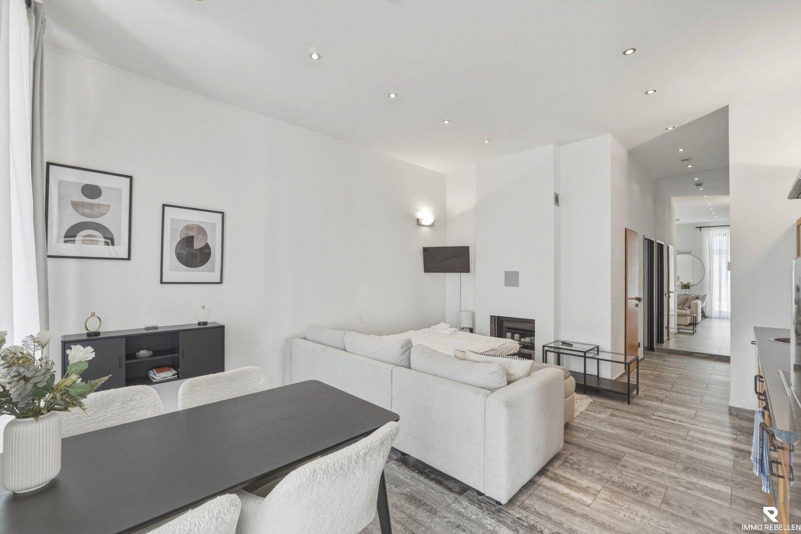 Geräumiger Wohnbereich mit modernem Sofa, Esstisch und Blick auf den Flur.