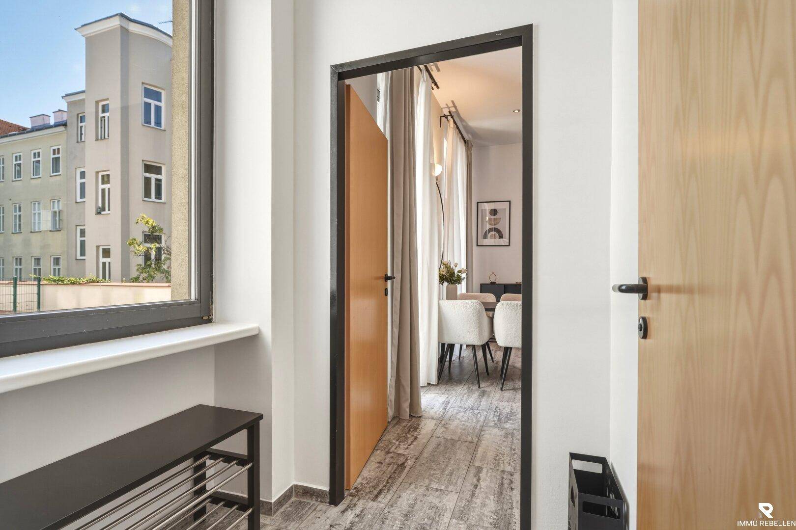 Eingangsbereich mit Schuhregal und offenem Blick in den Wohnbereich, praktisch gestaltet.