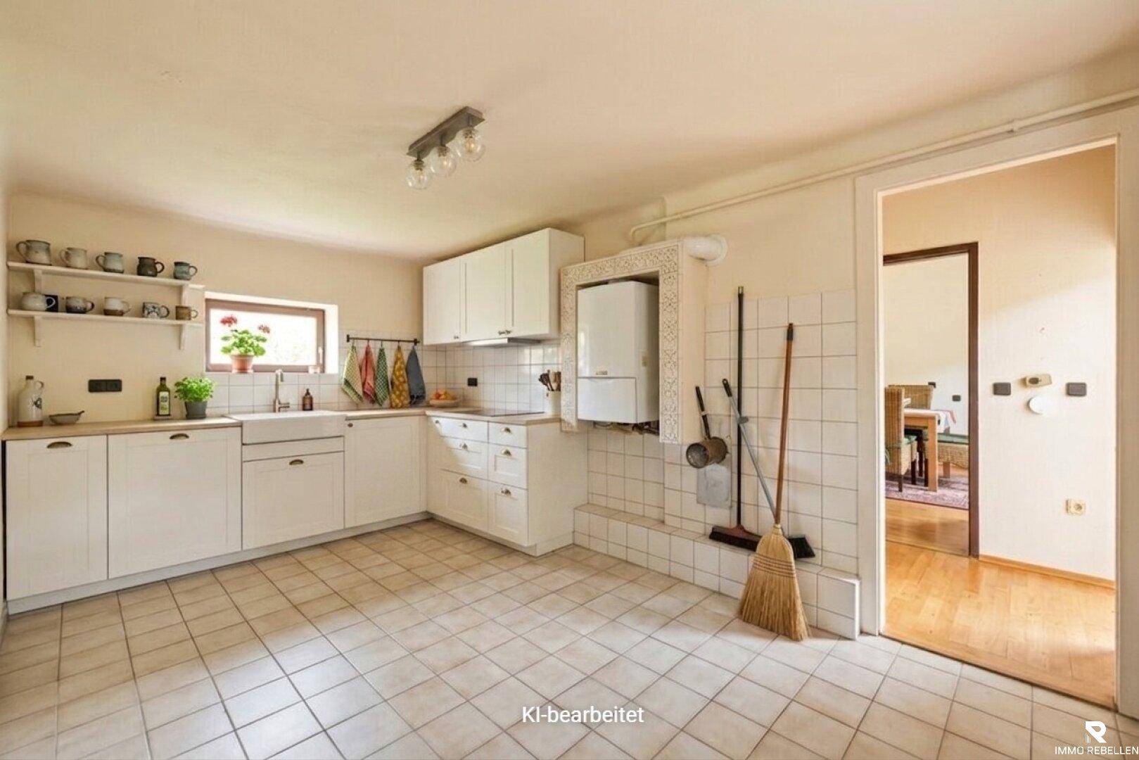 Helle Küche mit weißen Einbauschränken, Spüle und Fenster, bereit zur Modernisierung.