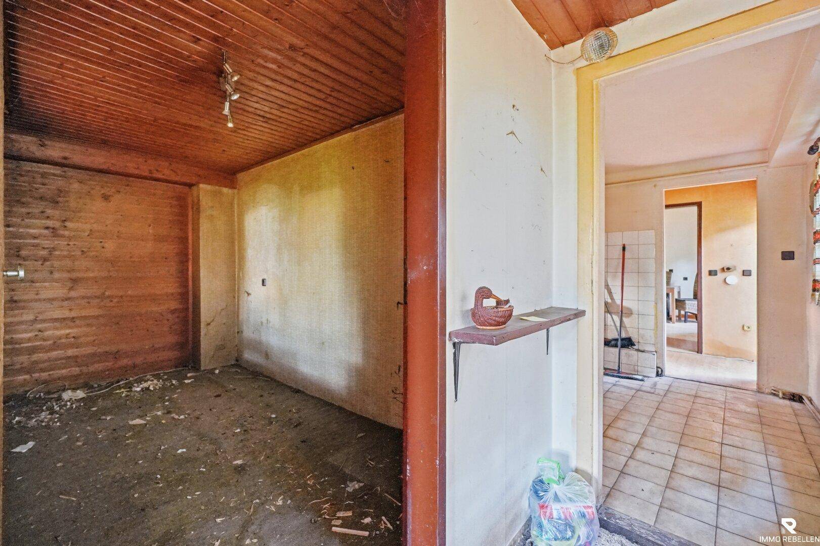 Leerer Raum mit Holzbalkendecke und Holzwänden, bereit für eine individuelle Gestaltung.