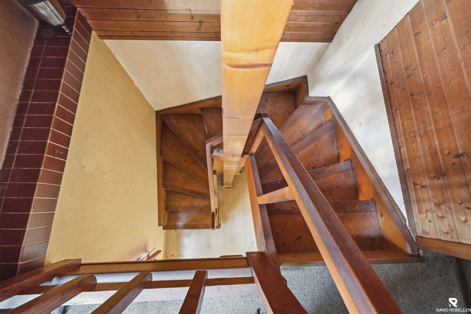 Blick von oben auf eine Holztreppe, die die verschiedenen Ebenen des Hauses verbindet.