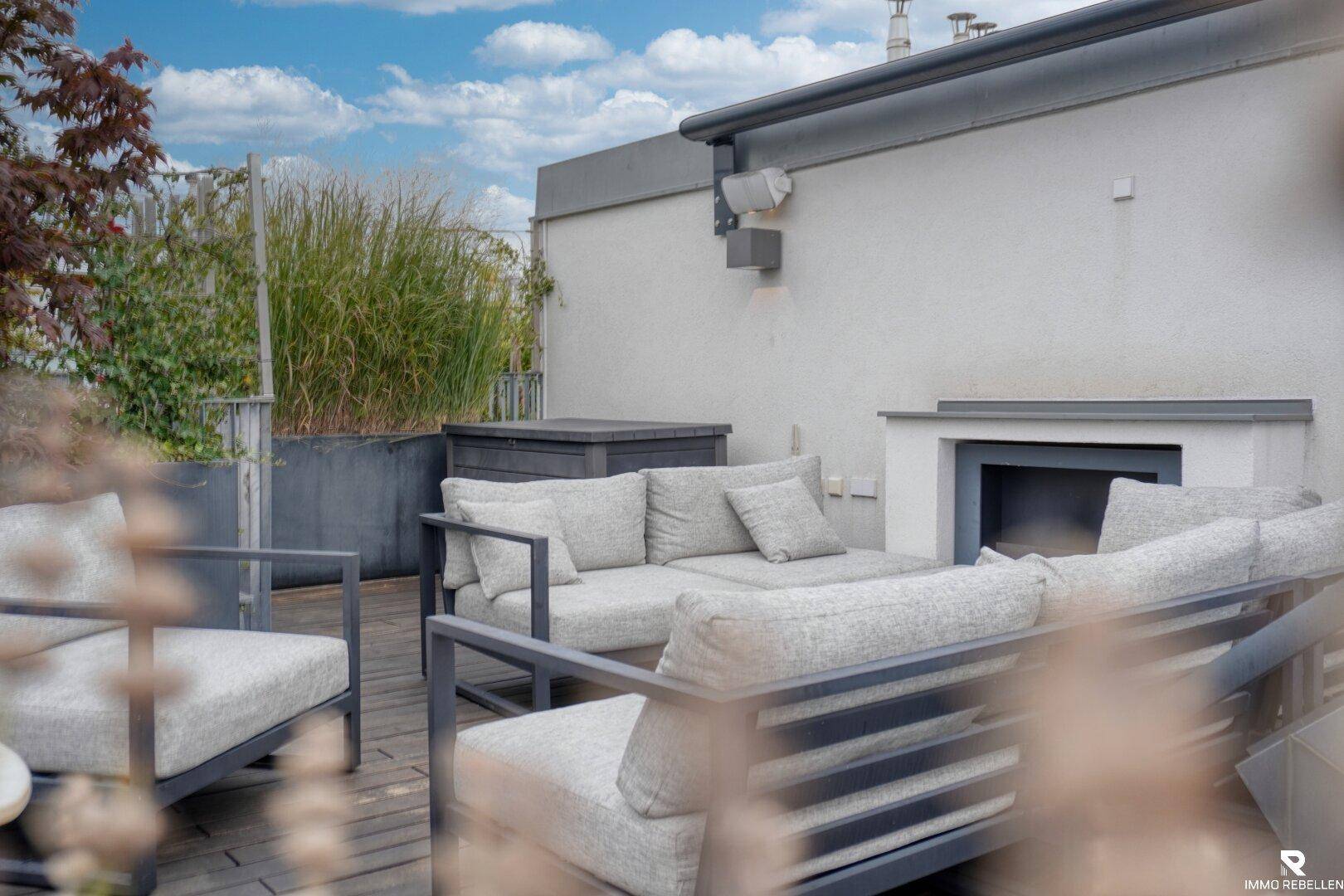 Gemütlicher Lounge-Bereich auf der Dachterrasse mit modernen Gartenmöbeln und Pflanzen.