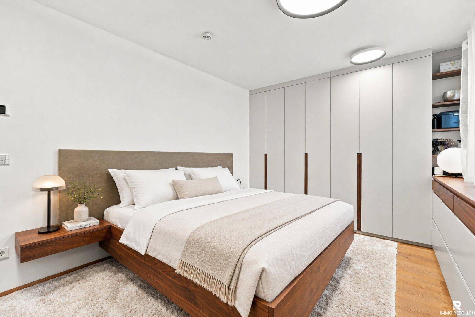 Gemütliches Schlafzimmer mit Doppelbett, Holzboden und Einbauschränken.