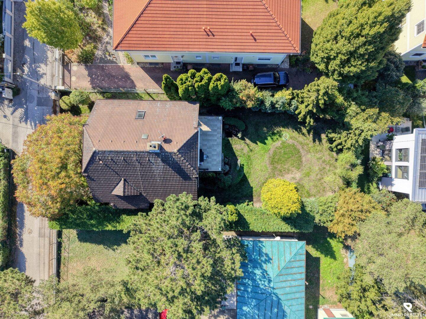 Draufsicht aus der Luft auf das Anwesen mit Garten, Nebengebäude und umliegenden Häusern.