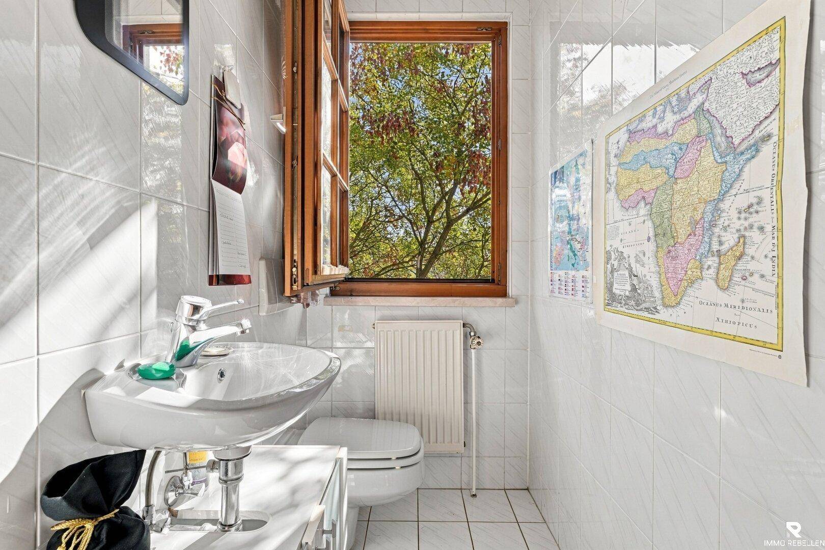 Kleines Gäste-WC mit Fenster, weiß gefliesten Wänden und Hänge-WC.