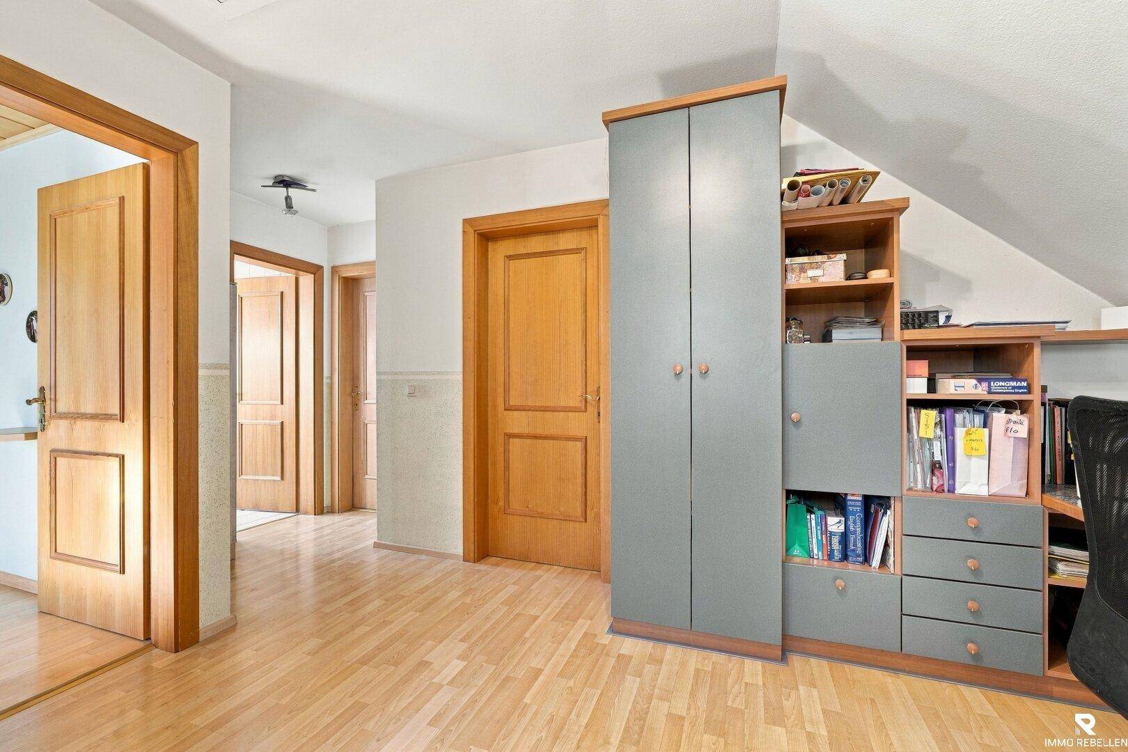 Heller Flur im Obergeschoss mit Holzboden und integrierten Schränken für Stauraum.