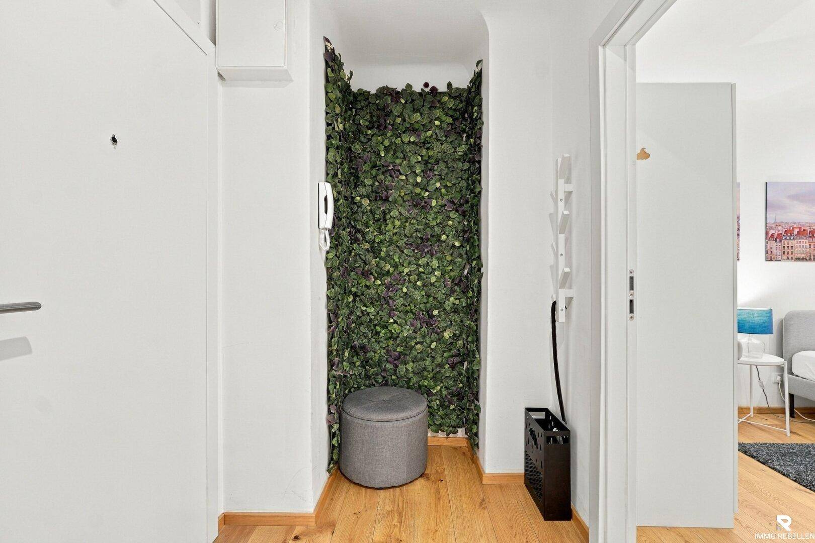 Eingangsbereich mit Holzboden und dekorativer Pflanzenwand.