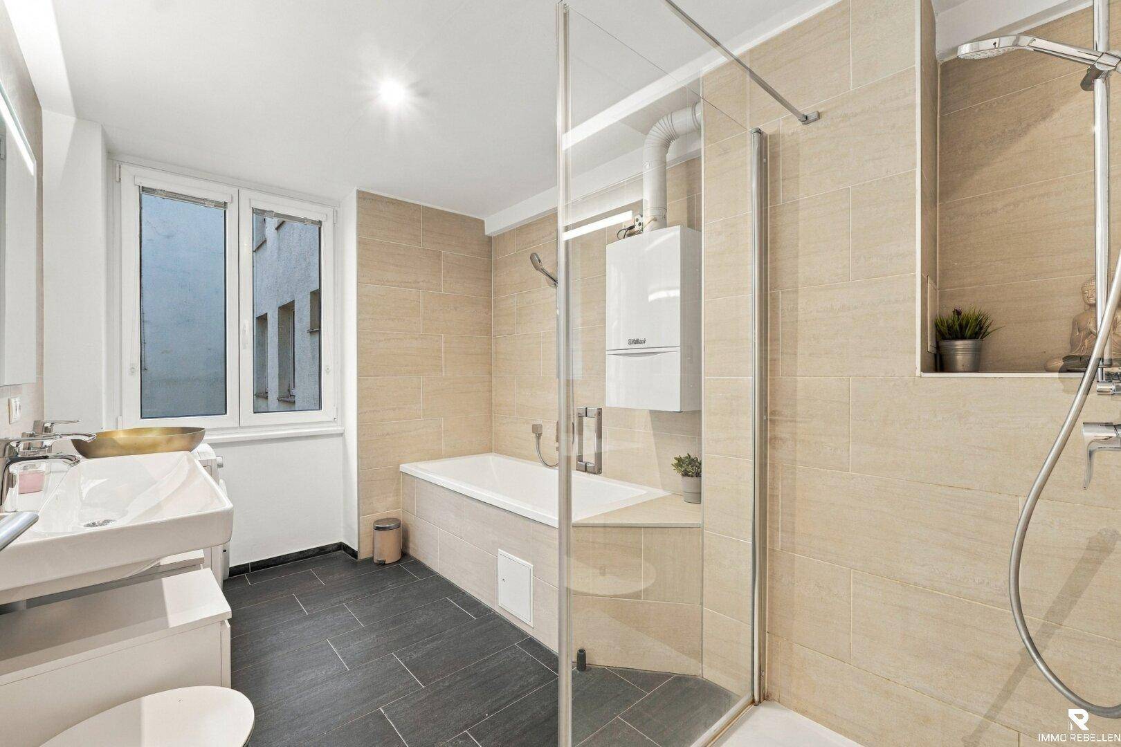 Modernes Badezimmer mit Badewanne, Dusche und Fenster.