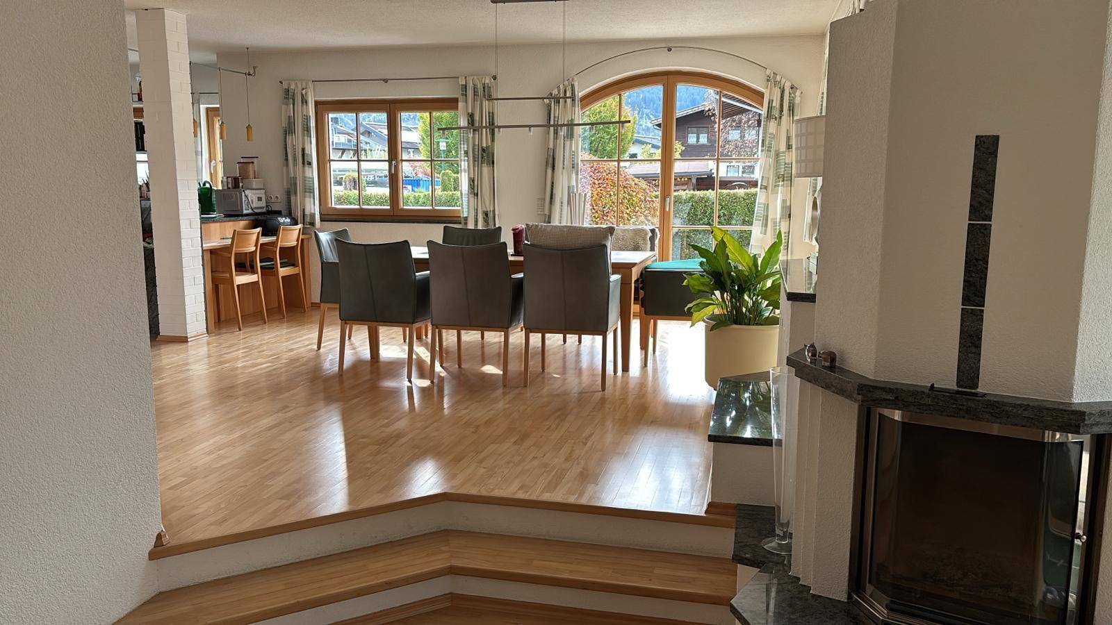 Geräumiger Wohn-Essbereich mit Holzboden, großem Esstisch und Kamin, mit Bergblick.