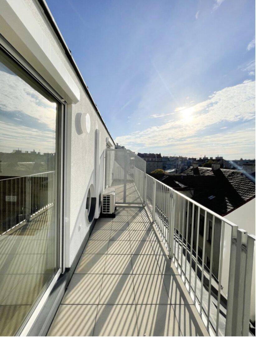Langer, schmaler Balkon mit Fliesenboden und weitem Blick über die städtische Umgebung.