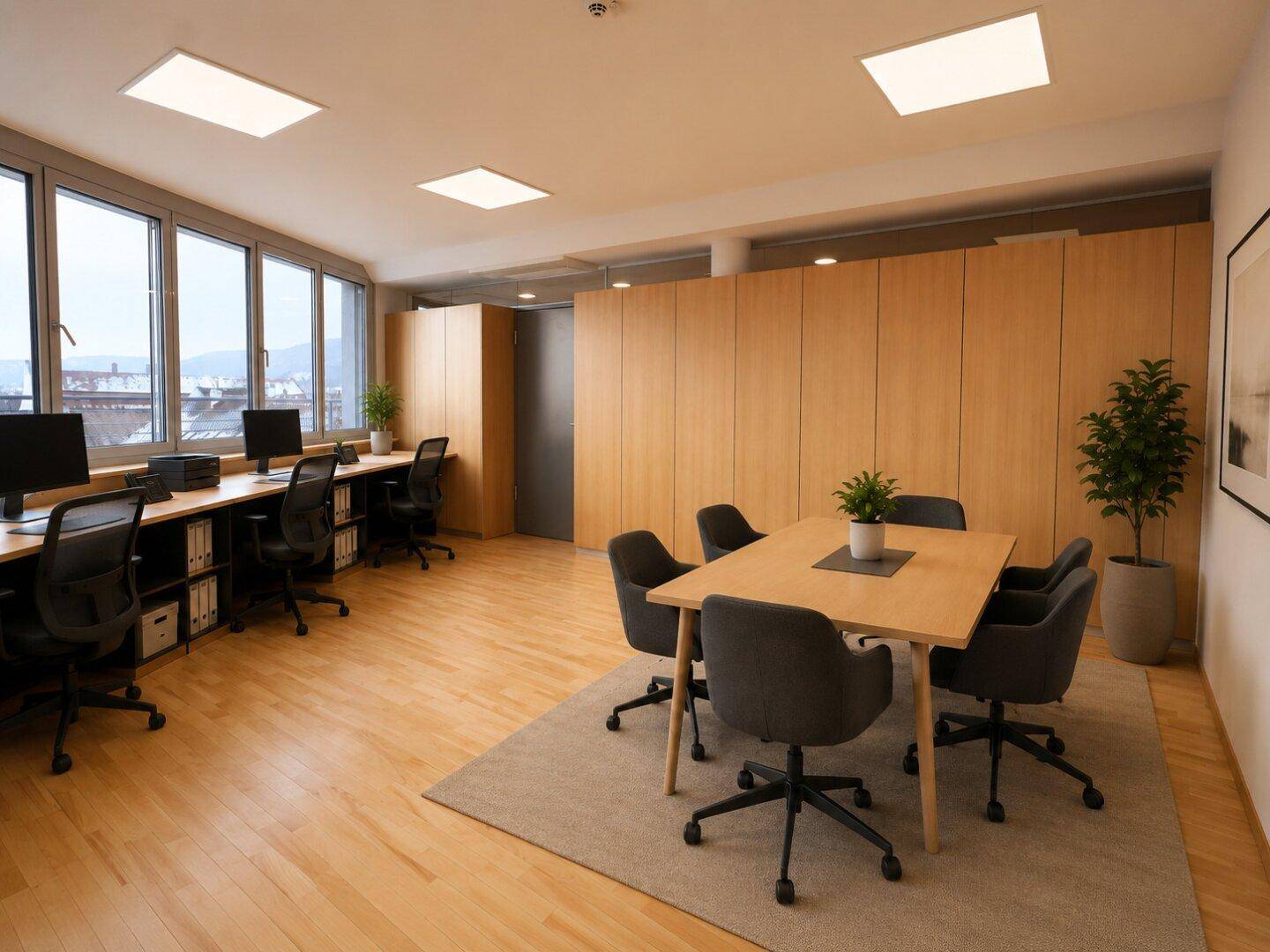 Modernes Großraumbüro mit mehreren Arbeitsplätzen, Konferenztisch und Panoramablick.