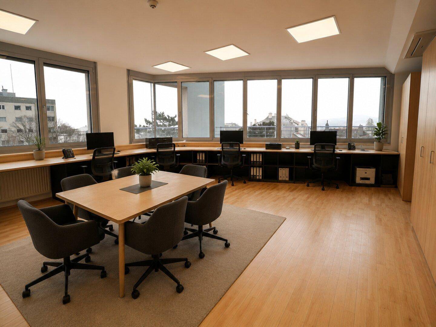 Großraumbüro mit mehreren Arbeitsplätzen, Konferenztisch und Panoramablick.