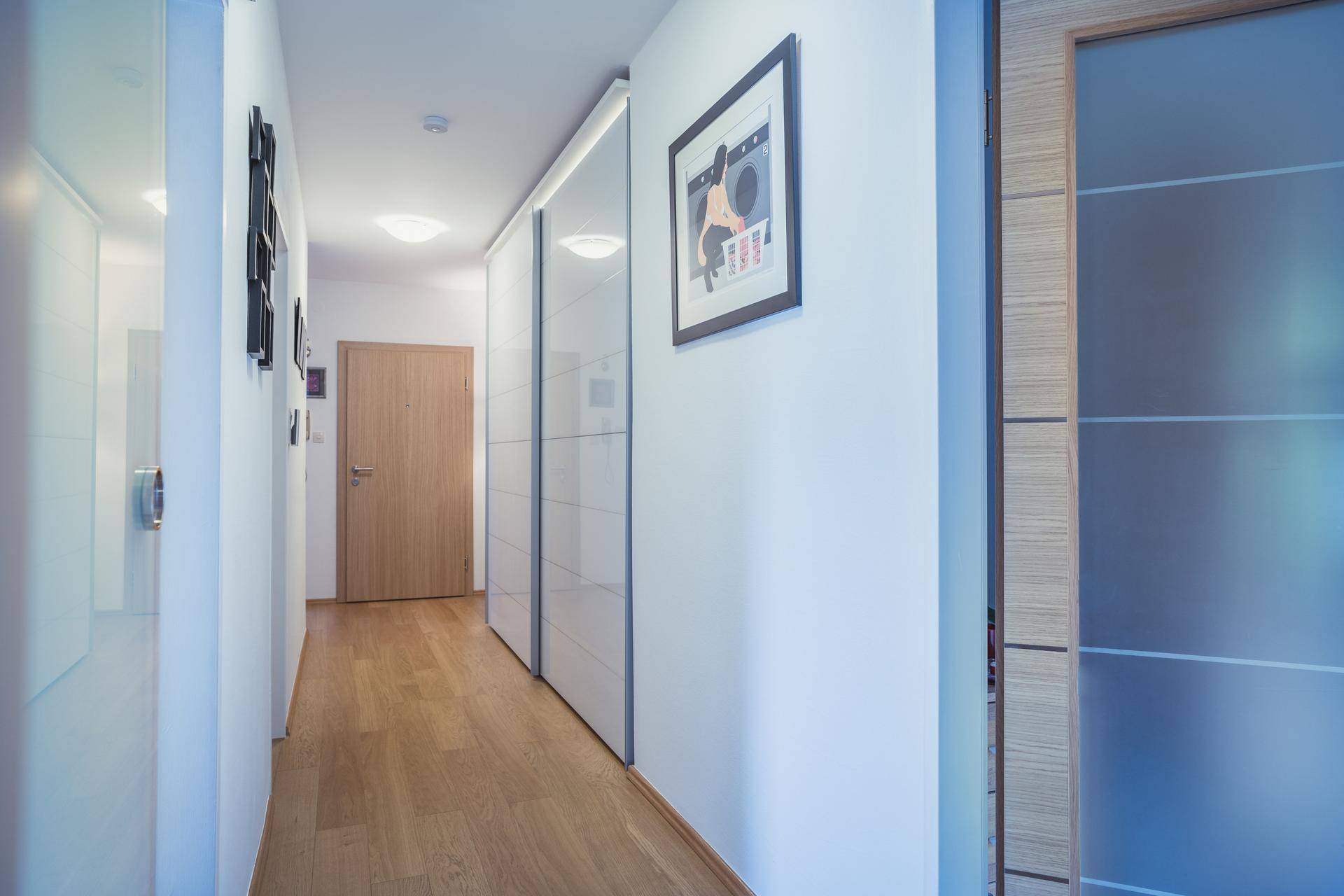 Heller Flur mit Holzboden, weißen Wänden und modernen Türen.