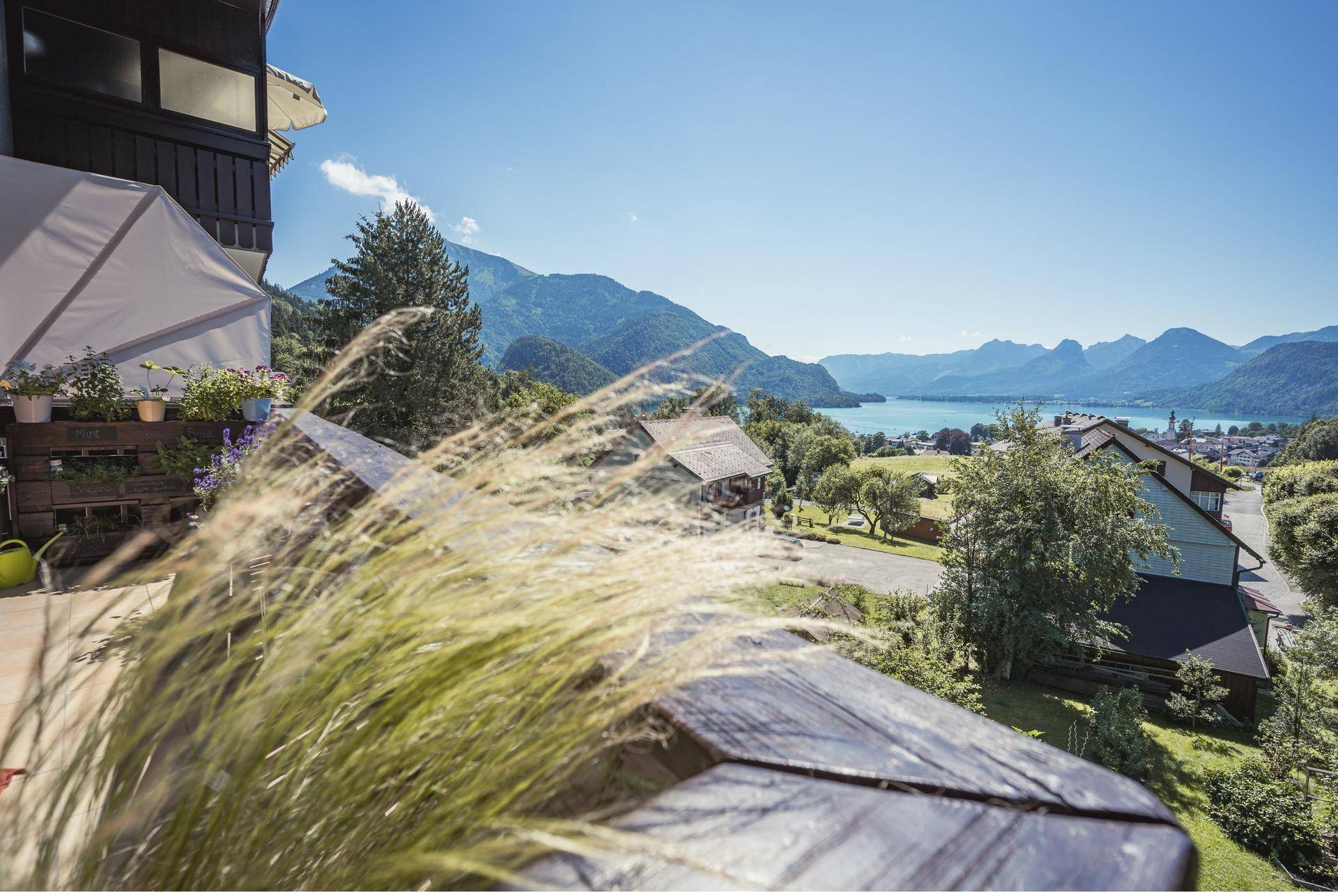 Sonniger Balkon mit weitem Blick auf die malerische Seenlandschaft und die majestätischen Berge.