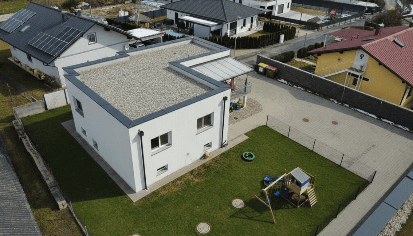 Luftaufnahme des modernen Hauses mit Flachdach, Garten und umliegender Wohnbebauung.