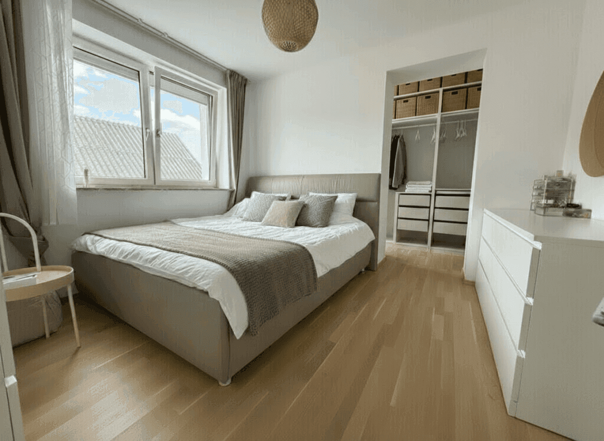 Geräumiges Schlafzimmer mit Doppelbett, Parkettboden und begehbarem Kleiderschrank.